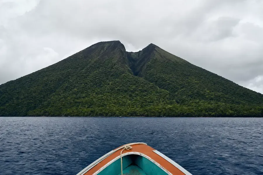 A volcanic island rising from open ocean, seen from the sea (AI-generated image)