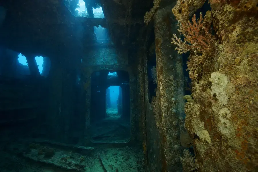 The interior of a large sunken steel ship, corridors receding into blue-green water (AI-generated image)