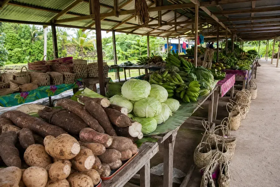 A covered produce market with tables of root vegetables and baskets (AI-generated image)
