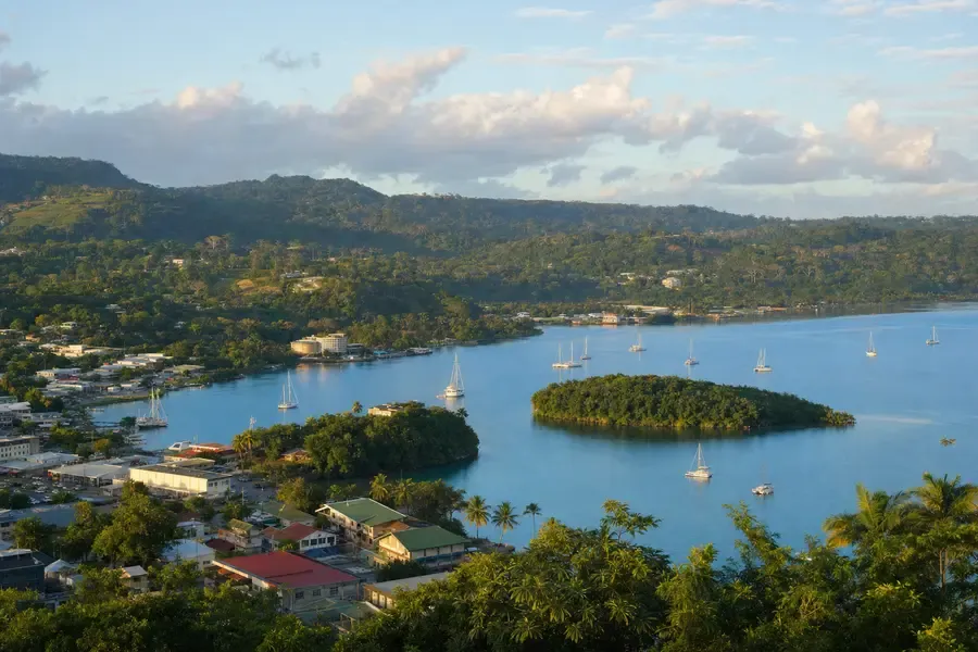 A sheltered harbour town seen from a hillside, a green island in the bay (AI-generated image)