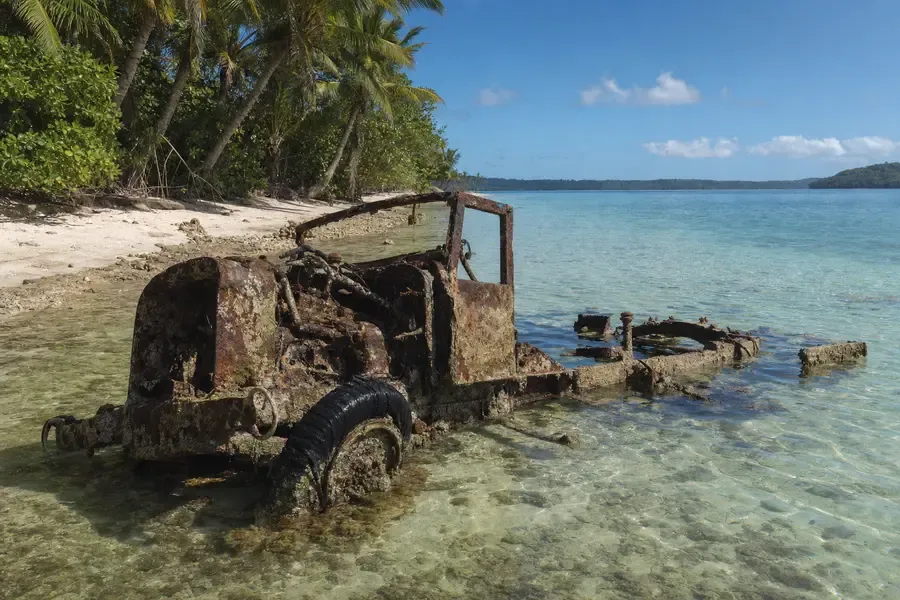 Rusting military machinery half-submerged in clear shallow water at a beach edge (AI-generated image)